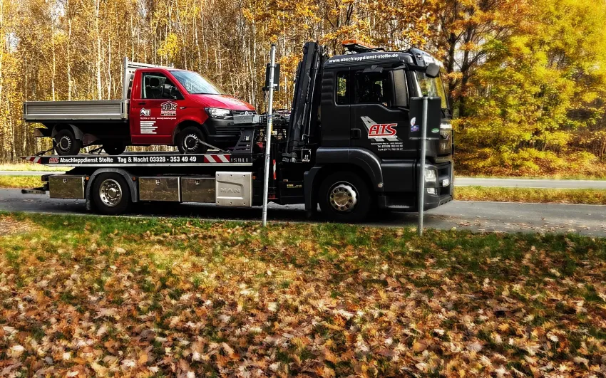 Abschlapp LKW Stolte, mit rotem Pritschenwagen auf der Ladefläche.